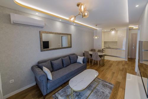 uma sala de estar com um sofá azul e uma mesa em Apartments Centrale 28 em Podgorica