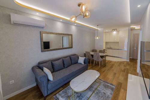 a living room with a blue couch and a table at Apartments Centrale 28 in Podgorica