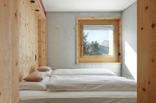 蓬特雷西納的住宿－Alpine Lodge 2-Bett-Wohnung Chesa Plattner "Bergbahnen All inklusiv" im Sommer，一间卧室设有两张床和窗户。