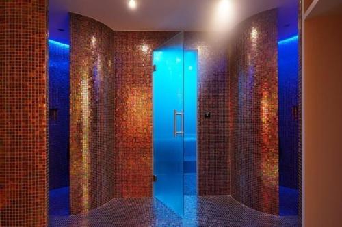 a bathroom with a walk in shower with a glass door at Alpine Lodge 2-Bett-Wohnung Chesa Plattner "Bergbahnen All inklusiv" im Sommer in Pontresina