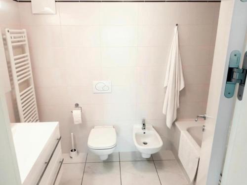 a white bathroom with a toilet and a sink at Süsse Wohnung mit bezaubernde Seesicht Apt 405 in Locarno