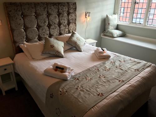 a bedroom with a large bed with white sheets and pillows at The Lady Elizabeth in Sudbury