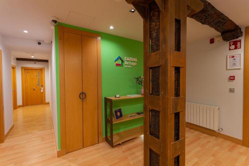 a room with a green wall and a wooden door at Casual Arriaga in Bilbao