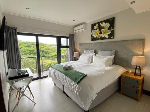 una camera con un grande letto e una finestra di Luxury Room with Private Balcony and Stunning Dam Views a Ballito