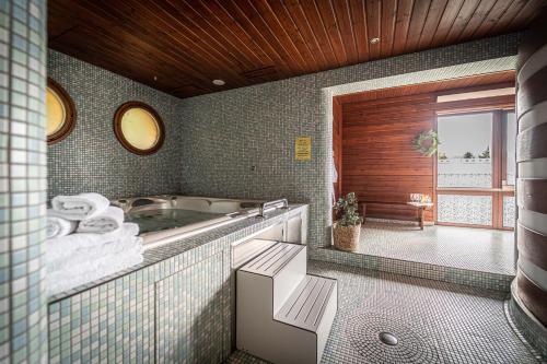 a bathroom with a bath tub and a window at Hotel Sluníčko in Ostravice