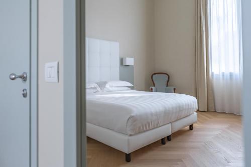 a bedroom with a white bed and a mirror at Hotel Ariele in Florence
