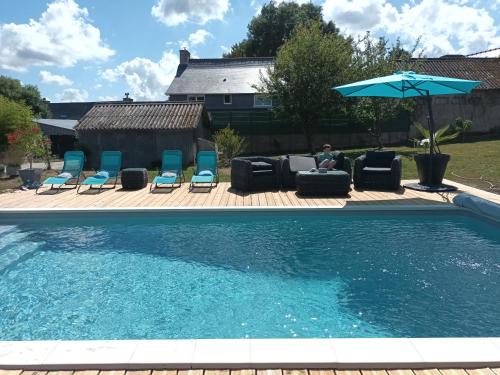 - une piscine avec des chaises, un parasol et un siège dans l'établissement Gîte avec piscine, à Mantallot