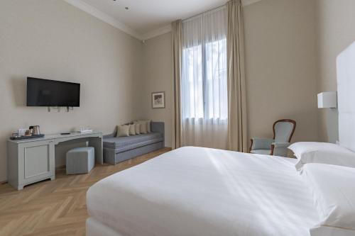 a hotel room with two beds and a television at Hotel Ariele in Florence