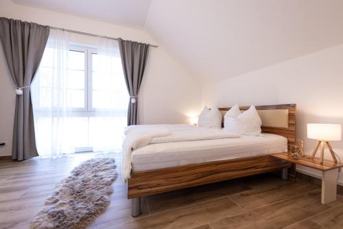a bedroom with a bed and a large window at Landhofmühle in Eltendorf
