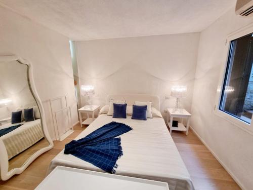 a bedroom with a large white bed with blue pillows at House Casbah Porto Rotondo in Porto Rotondo