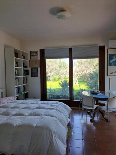 1 dormitorio con 1 cama grande, mesa y sillas en Casa Gelsomino, en Carlentini