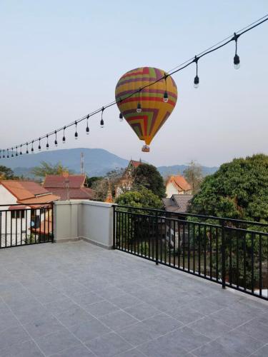 a hot air balloon flying over a balcony at ChanthaSouk Vang Vieng Entire Villa in Vang Vieng
