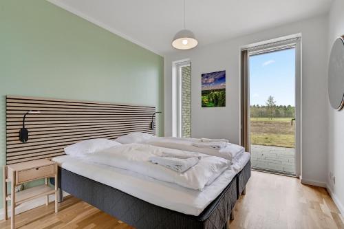 a bedroom with a large bed and a large window at Lübker Golf Resort in Nimtofte