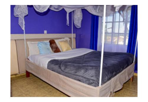 a woman laying on a bed in a bedroom at Rozala Motel in Bondo