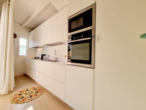 a kitchen with white cabinets and a microwave at House Casbah Porto Rotondo in Porto Rotondo