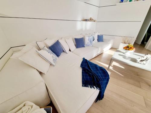 a white couch with blue pillows in a living room at House Casbah Porto Rotondo in Porto Rotondo