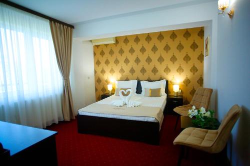 a hotel room with a bed with a flower on it at Casa Coral Mamaia Nord in Mamaia Nord