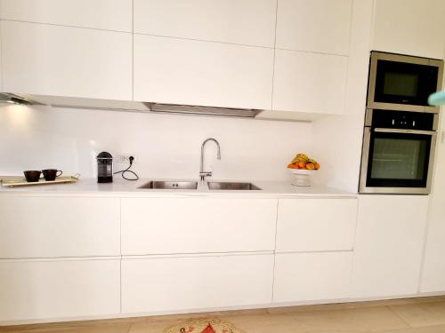a kitchen with white cabinets and a sink at House Casbah Porto Rotondo in Porto Rotondo