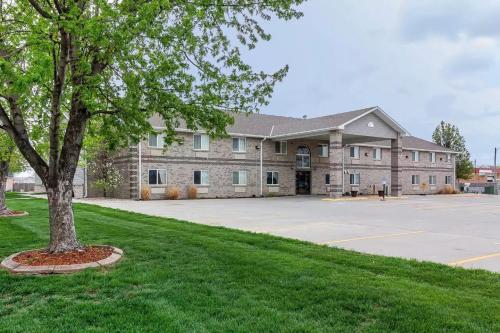 a large building with a tree in front of it at Rodeway Inn in Holdrege