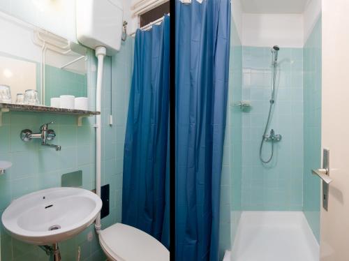 baño con cortina de ducha azul y lavamanos en HOTEL KRALJEVICA, en Kraljevica