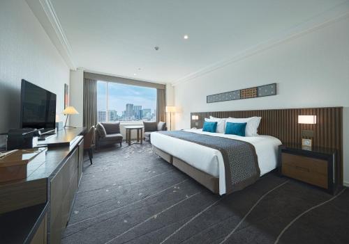 a hotel room with a bed and a television at The Prince Sakura Tower Tokyo, Autograph Collection in Tokyo
