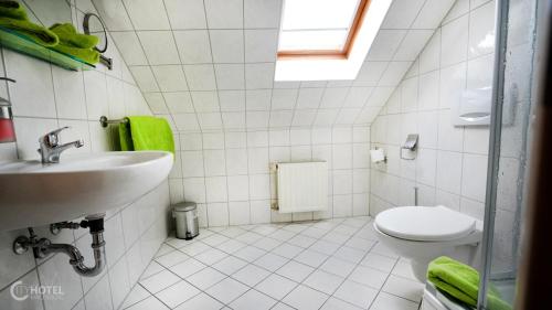 ein Bad mit einem Waschbecken und einem WC in der Unterkunft Cityhotel Magdeburg in Magdeburg