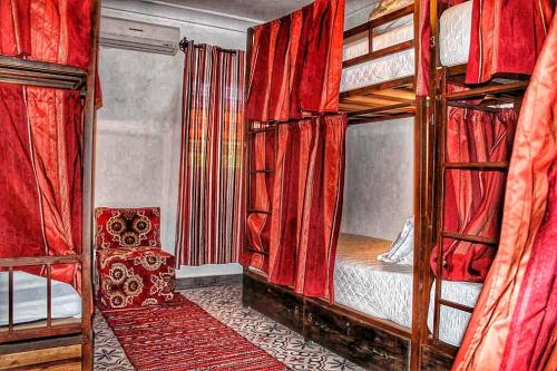 a bedroom with two bunk beds with red curtains at Hostel Dar Ben Youssef in Marrakesh