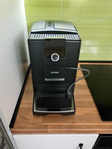 une machine à café noire assise sur un comptoir dans l'établissement Włókna Inn Classic, à Potrzanowo