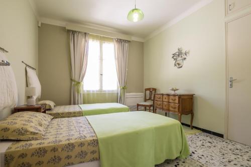 1 Schlafzimmer mit 2 Betten, einem Schreibtisch und einem Fenster in der Unterkunft Villa Enzo in Orgon