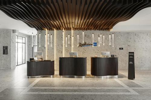 a lobby with two desks and a ceiling with chandeliers at Radisson Blu Resort & Conference Center, Ostróda Mazury in Ostróda