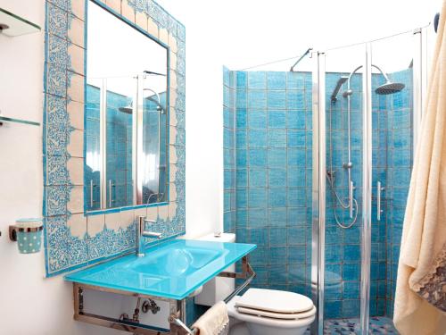 ein Badezimmer mit einem blauen Waschbecken und einer Dusche in der Unterkunft Sea and the City in Taormina