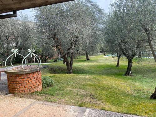 a park with trees and a bench in the grass at Villa Sweet Flower - with Private Pool and Garden in Manerba del Garda