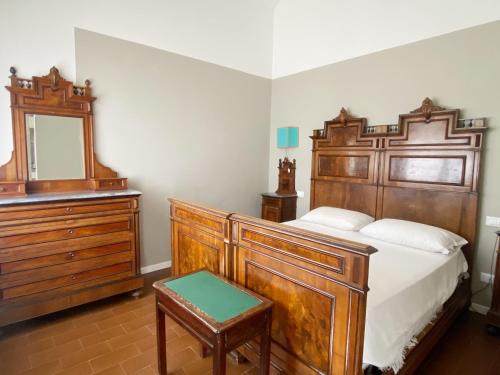 a bedroom with a large wooden bed and a mirror at Villa Sweet Flower - with Private Pool and Garden in Manerba del Garda