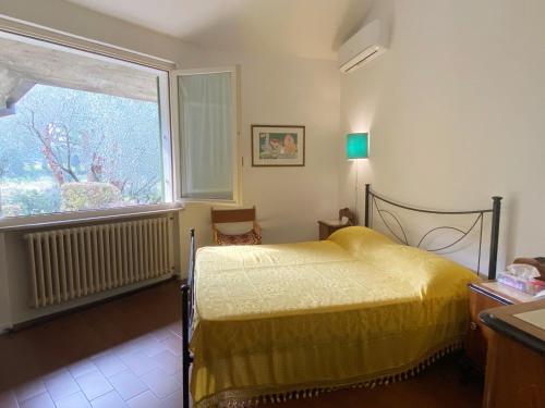 a bedroom with a yellow bed and a window at Villa Sweet Flower - with Private Pool and Garden in Manerba del Garda