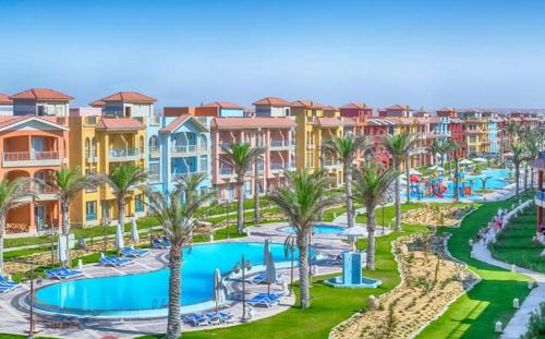 an aerial view of a resort with a pool and palm trees at Porto matrouh chalets in Marsa Matruh