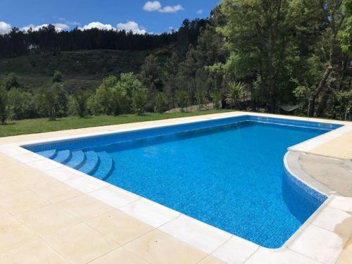 a large blue swimming pool in a yard at Quinta da Fervença, private river place to relax.. in Sernancelhe