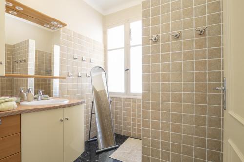 ein Bad mit einem Waschbecken und einer Dusche mit einem Spiegel in der Unterkunft Villa Enzo in Orgon