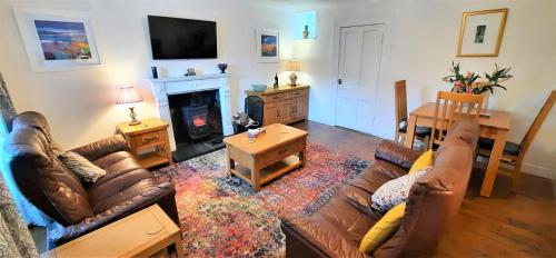 ein Wohnzimmer mit einem Sofa und einem Kamin in der Unterkunft Greenbrae East in Crieff