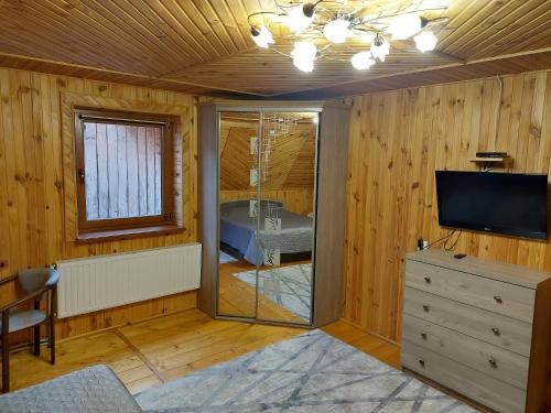 ein Wohnzimmer mit einem TV und einer Kommode in der Unterkunft Holiday Home La Vіta in Jaremtsche