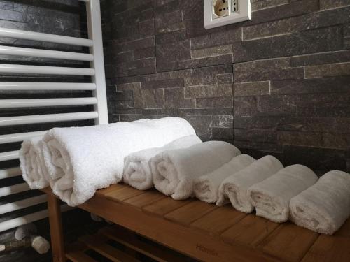a pile of white towels sitting on a wooden bench at Soulmate Rooftop Apartment in Rome