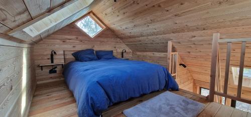 1 dormitorio con 1 cama en una cabaña de madera en Les cabanes des Pierreux en Gesves