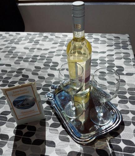 a bottle of wine and two glasses on a table at Hámori Álom in Miskolc