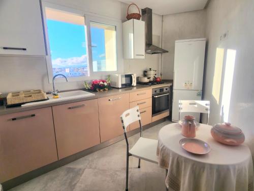 a kitchen with a table and a table and chairs at Accueillant S+1 jardin de carthage in Tunis