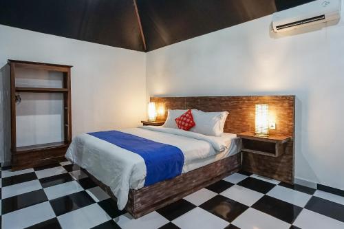 a bedroom with a bed and a checkered floor at Kampung 168 in Jimbaran