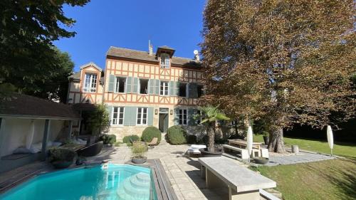 une maison avec une piscine dans la cour dans l'établissement Belle demeure avec piscine, vue et accès direct à la Seine, très proche de Paris, à Carrières-sur-Seine