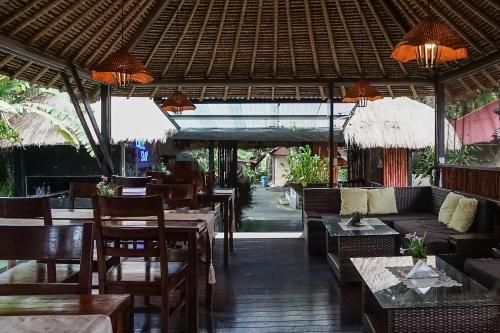 restauracja ze stołami i krzesłami oraz częścią wypoczynkową w obiekcie Kampung 168 w mieście Jimbaran