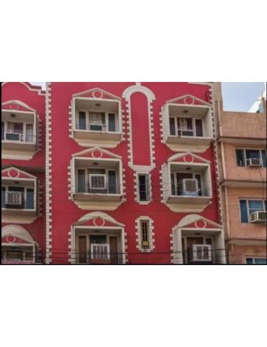 ein rotes Gebäude mit Seitenfenstern in der Unterkunft Hotel Diamond, Jammu in Jammu