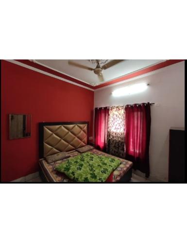 um quarto com uma cama e uma parede vermelha em Hotel Diamond, Jammu em Jamu