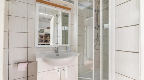 une salle de bain blanche avec un lavabo et une douche dans l'établissement Sun Village- 59- Maison spacieuse- 4 pers, au Cap d'Agde