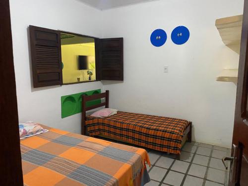 um quarto com duas camas e um espelho em Japaraiso I Casa Azul - Próxima ao Mar em Japaratinga